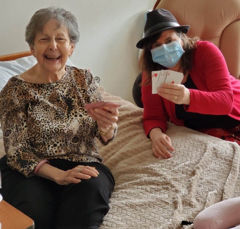 JoAnne Klimovich Harrop (right) playing cards with nursing home resident Rosie Wyner during the COVID-19 pandemic. (Photo courtesy of JoAnne Klimovich Harrop)