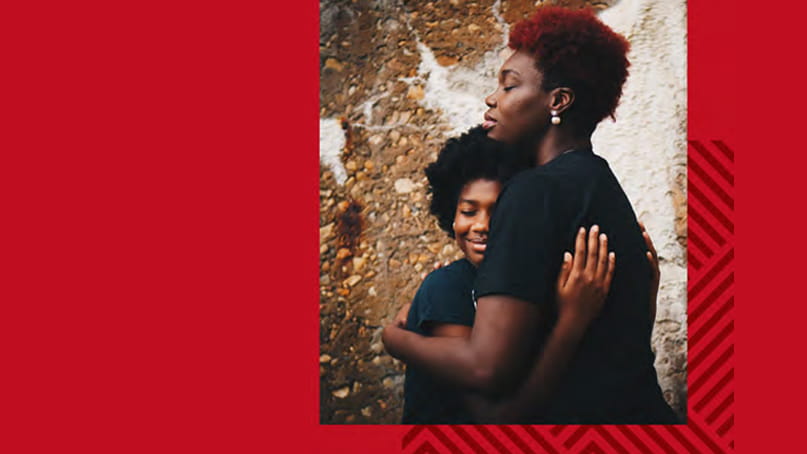 A Black woman and child hugging on a red background