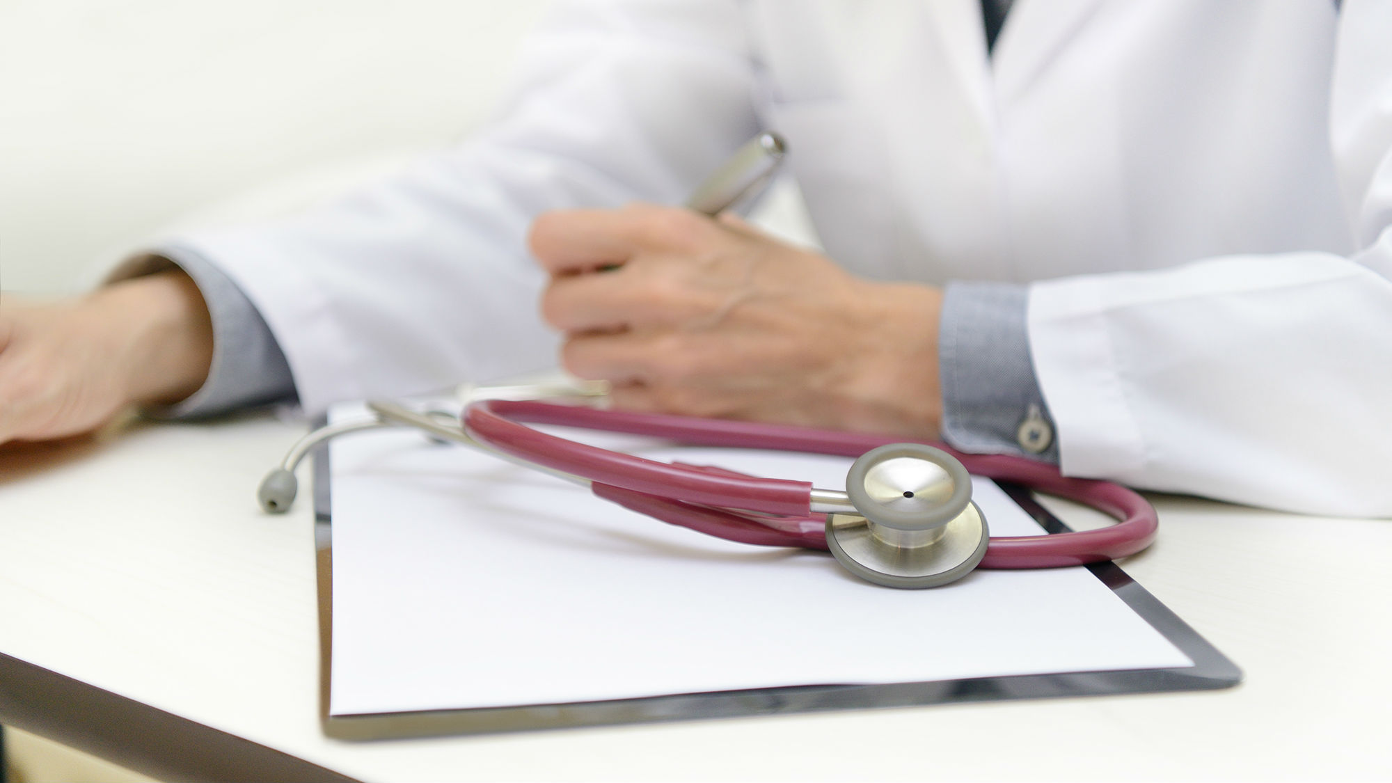 Doctors hands with stethoscope and clipboard