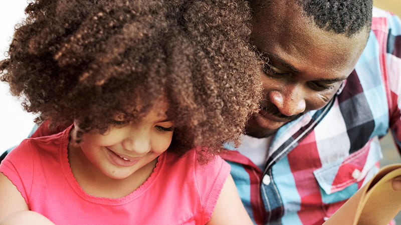 father and daughter reading book