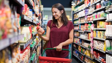 Caucasian woman reading food label in grocery store isle