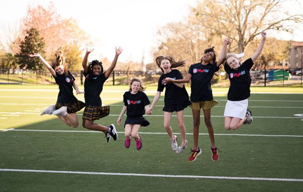 Kids jumping on a football field.