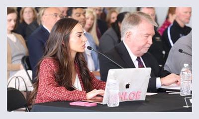 seated woman speaking into microphone at advocacy event