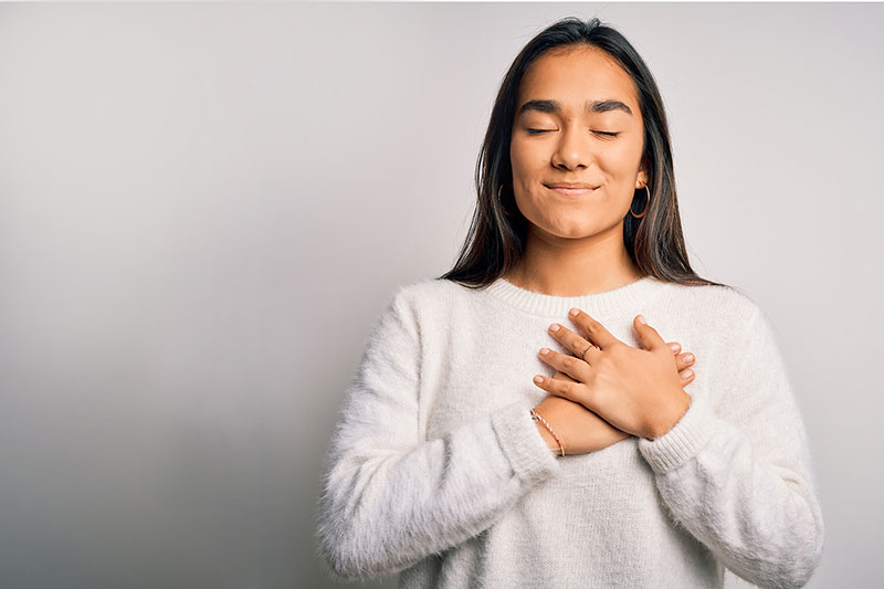 thankful woman with hand over heart