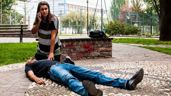 woman calling for help for man on ground