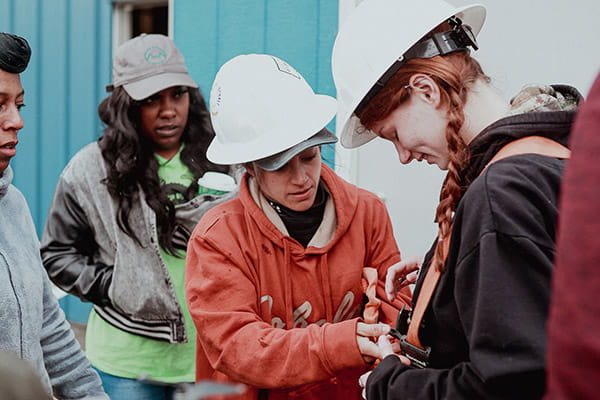 A group of West Virginia Women Work participants are gearing up with safety equipment for a job assignment.