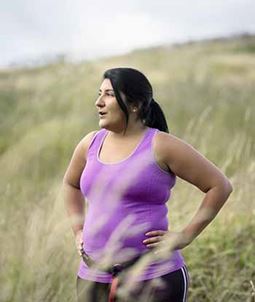 Woman in field resting after exercise