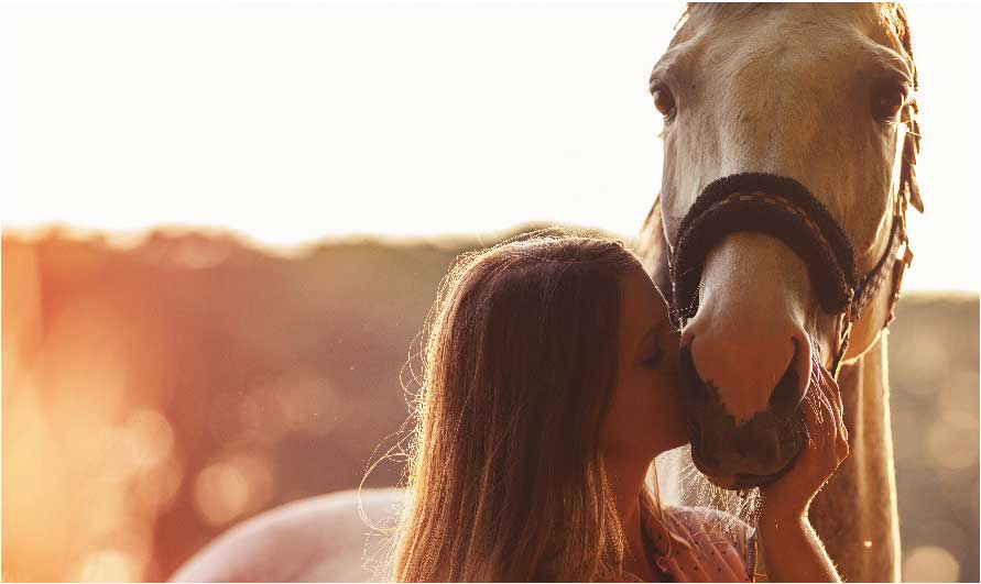 young women kissing her horse